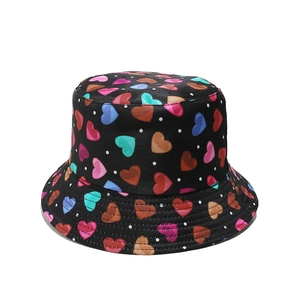 Dettaglio cappello alla pescatora nero con cuori arcobaleno colorati e pois bianchi