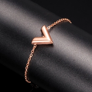 Macro shot of rose gold V-shaped pendant bracelet on a professional textured black stand