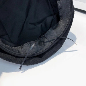 Detail view of the black newsboy hat interior showing sweatband and adjustable drawstring