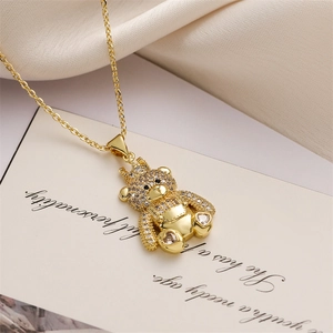 Macro view of a gold bear pendant with crown and rhinestones on a stylish chain