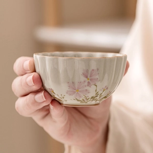 Handcrafted ceramic daisy teacup with floral patterns and scalloped edge detail