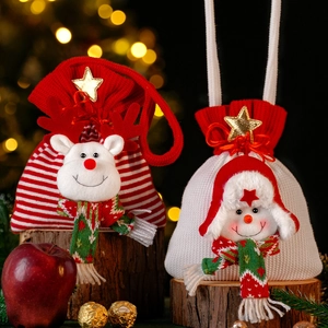 Christmas gift bags with reindeer and snowman plush dolls on wooden base with tree background