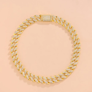 Detail of gold-plated Cuban link necklace with sparkling rhinestones on pink background