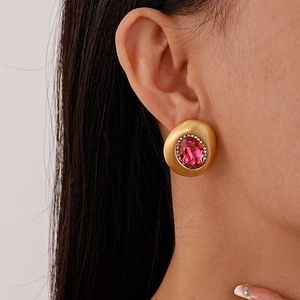 Nahaufnahme von Vintage-Ohrsteckern mit ovalem rosa Edelstein und Strass am Model