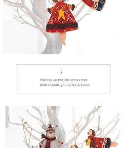 Detail of wooden deer and angel Christmas ornaments hanging on a white decorative tree