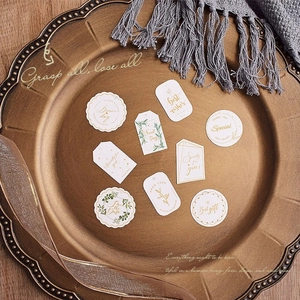 Elegant assorted paper gift tags with gold foil lettering and botanical patterns for weddings