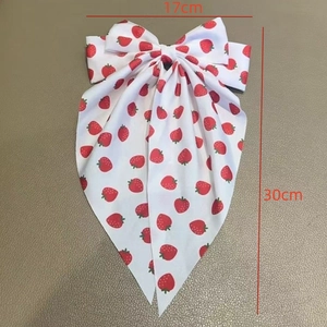 Sweet white bow hair clip with red strawberry print featuring long elegant ribbons