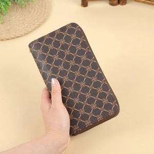 Classic brown long zip-around wallet with golden clover patterns held by a hand