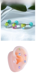 Makro-Detail von sternförmigen Zirkon-Ohrsteckern mit bunten Kristallen an einem Ohrmodell