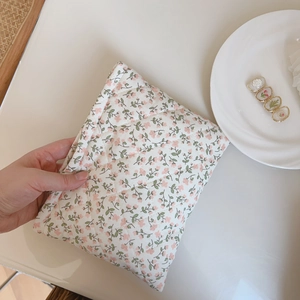 Detailed macro view of pink floral quilted fabric texture and diamond stitching on pouch