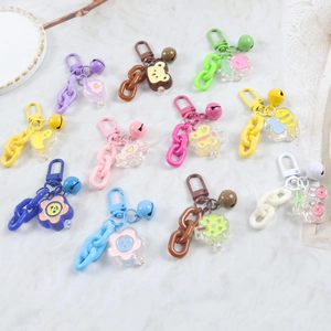 Colorful resin chain keychains with acrylic cartoon charms and bells on marble background