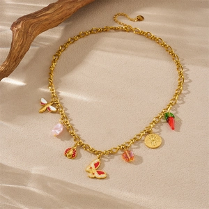 Golden necklace set with colorful butterfly charms and pearls on natural wood