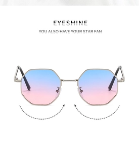 Close-up of golden octagonal metal frame sunglasses with blue-pink gradient lenses