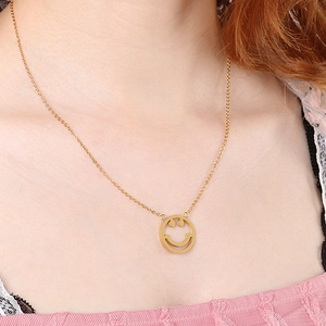 Détail du pendentif visage souriant plaqué or 18K porté sur le cou avec élégance