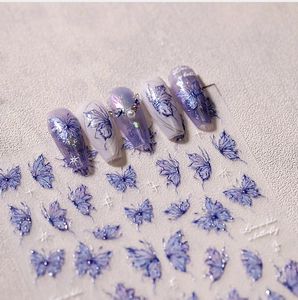 Macro detail of 3D embossed butterfly nail stickers with glitter and aurora effects