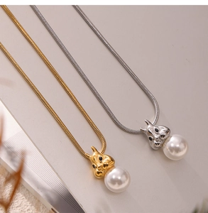 Close-up of snake chain necklaces with gold and silver rabbit pendants and white pearls