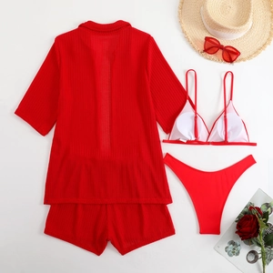 Flat lay detail of red four-piece swimwear set showing textured ribbed fabric and resort style