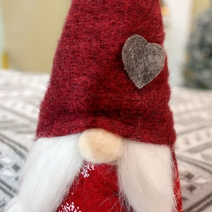 Dettaglio macro del cappello dello gnomo di Natale in feltro rosso con cuore grigio