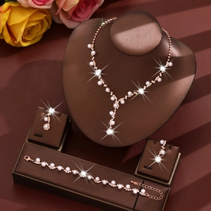 Elegant rose gold jewelry set with white pearls and sparkling crystals on display