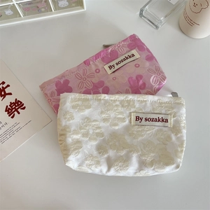Close-up of floral embossed texture and silver zipper on the jacquard makeup pouch