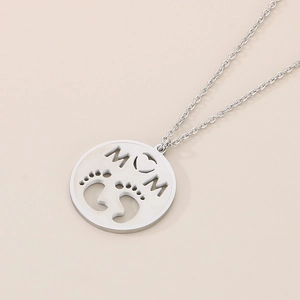 Macro shot of silver stainless steel necklace with engraved MOM and baby feet pendant