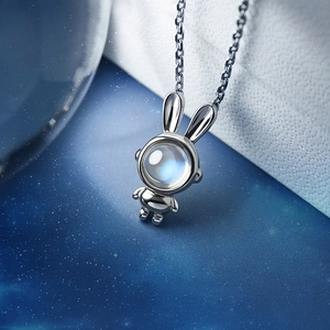 Astronaut rabbit necklace with moonstone pendant on a dark starry sky background