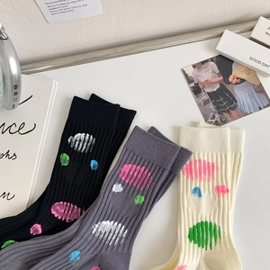 Detailed view of three pairs of ribbed cotton socks in black, grey, and beige colors