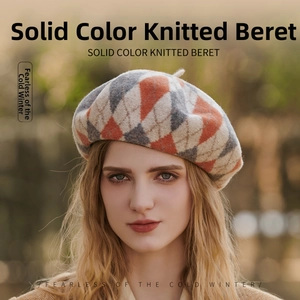 Detail of knitted wool beret featuring classic orange and grey argyle pattern texture
