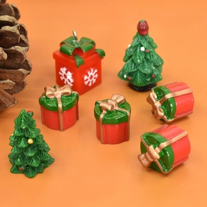 Miniature resin Christmas gift boxes and trees on orange background for DIY decor