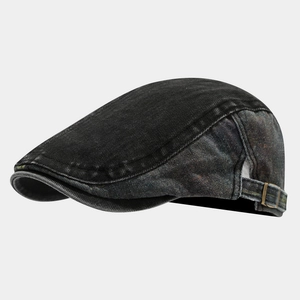 Detail view of washed denim flat cap with adjustable metal buckle and distressed finish