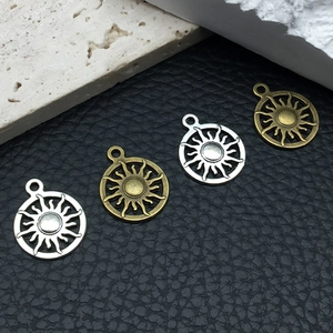 Macro shot of vintage sun-shaped metal charms in antique silver and bronze finishes