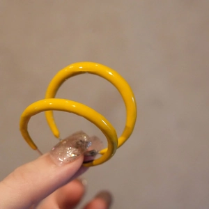 Minimalistische geometrische gelbe Emaille-Ohrstecker in runder Form zur Schau