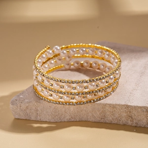 Detail of multi-layer spiral bracelet with imitation pearls and sparkling rhinestones