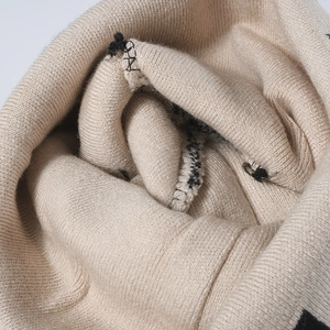 Close-up of beige checkerboard knit beanie showing premium texture and warm stitching