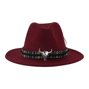 Dettaglio del cappello di lana bordeaux con fascia etnica e ornamento a testa di toro