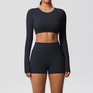 Detail of black long-sleeve crop top and high-waist shorts in matte elastic gym fabric