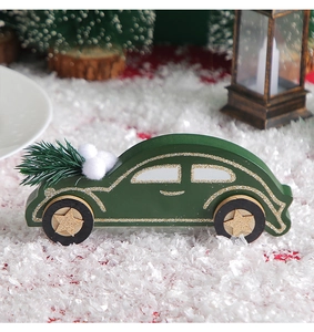 Detailed view of dark green wooden car ornament with gold glitter and pine needles