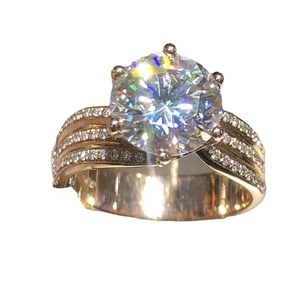 Classic six-prong gold ring featuring a round zircon center stone and triple row pavé accents