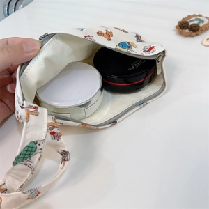 Détail de la pochette en toile montrant l'espace cosmétique avec imprimés animaux mignons