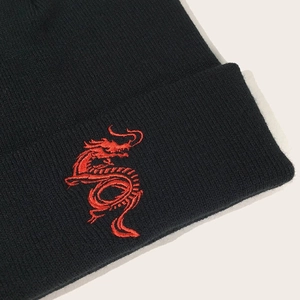 Detail of red dragon embroidery on black ribbed knit beanie for winter wear