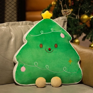 Plush Christmas tree pillow with cute smiley face and star detail on a leather sofa