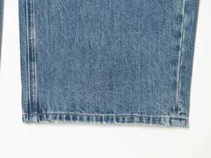 Detailaufnahme von Rollsaum und Nähten an blauen Jeans mit Used-Effekt