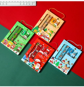 Close-up of four colorful Christmas stationery gift sets with pencils and notebooks