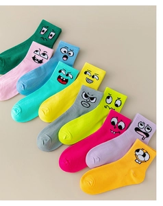 Close-up of vibrant athletic socks with various funny embroidered cartoon face expressions