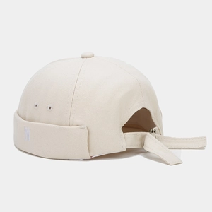Detail of beige miki hat featuring white N embroidery and adjustable metal buckle