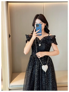Detailed view of model wearing a mini heart rhinestone chain bag with a polka dot dress