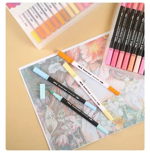 Detail of double head watercolor markers with dual tips on floral drawing and plastic storage box