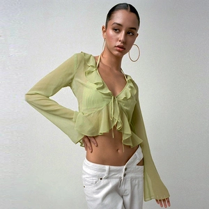 Detail of light green sheer long sleeve top with ruffle edges and front tie closure