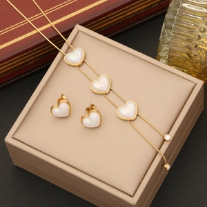 Elegant gold heart pearl jewelry set with bracelet and earrings on a luxury gift box