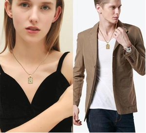 Lifestyle view of a 18K gold stainless steel square pendant featuring letter U for men and women